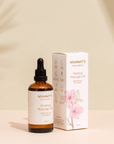 Organic Perineal Massage Oil on a warm beige studio background.