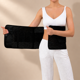 Black Postpartum Belly Band shown open on a model against a natural beige studio backdrop.
